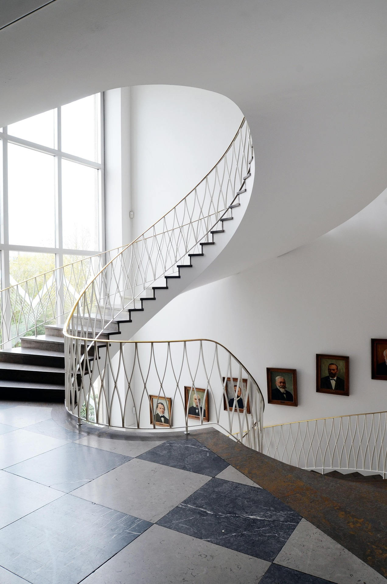 "Custom curved staircase railing installation featuring decorative metal balusters and elegant architectural stair design in a modern interior."